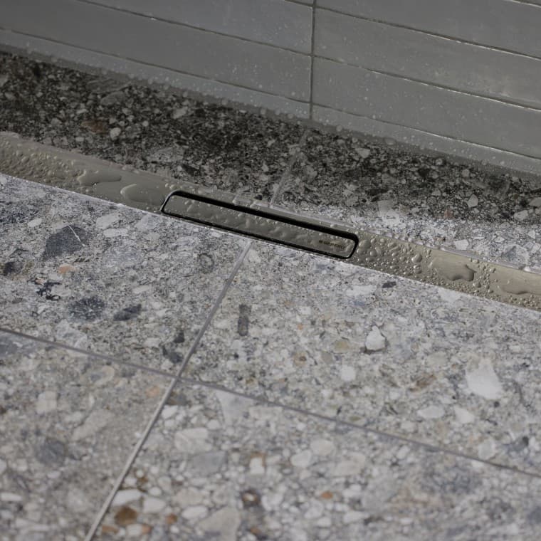 Voda odteka po elegantnem profilu iz nerjavečega jekla. Voda odteka po elegantnem profilu iz nerjavečega jekla.