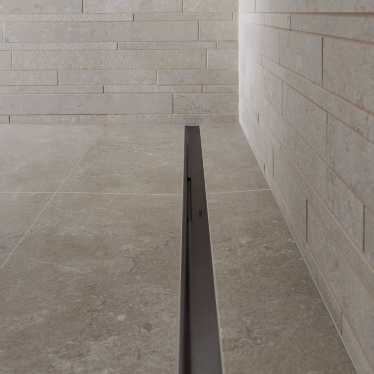 Voda odteka po elegantnem profilu iz nerjavečega jekla. Voda odteka po elegantnem profilu iz nerjavečega jekla.