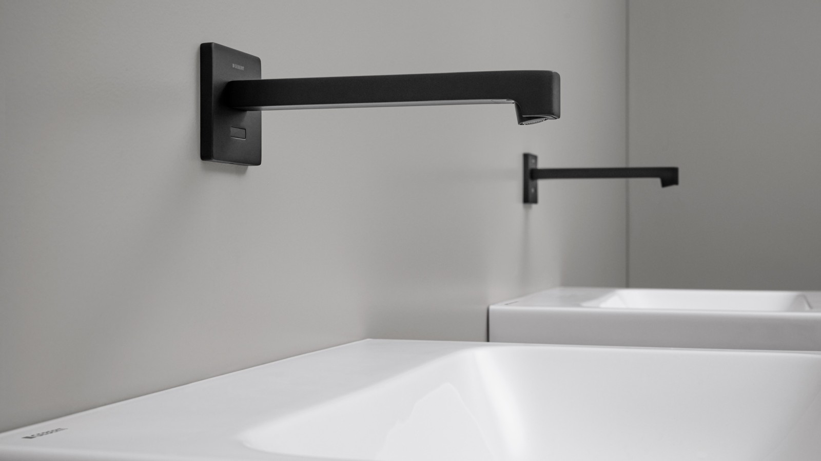 Geberit Brenta touchless washbasin tap. Wall-mounted tap in a square design in black matt Geberit Brenta touchless washbasin tap. Wall-mounted tap in a square design in black matt
