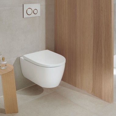 Bela WC-keramika v kopalnici z lesenimi elementi ohranja moderen videz tudi po mnogih letih (na sliki: WC Geberit iCon in aktivirna tipka Geberit Sigma20).