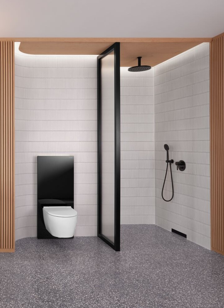 Kopalnica z leseno steno ter prostorom za prhanje in WC v črno-beli barvi
