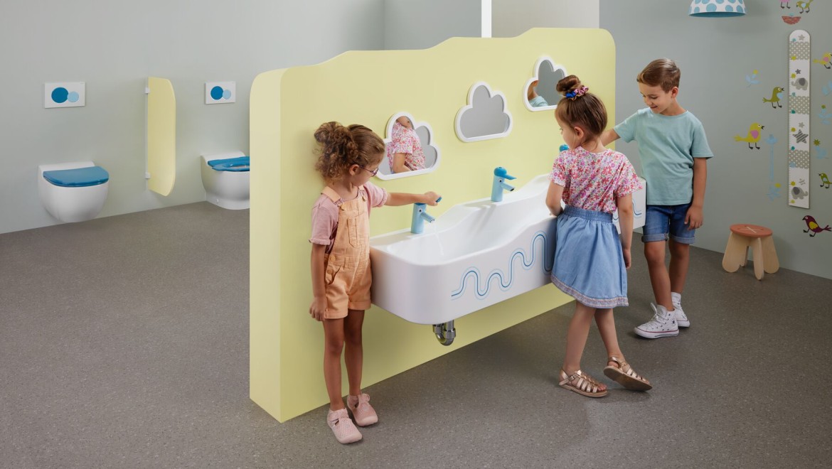 Otroci se igrajo v sanitarnem prostoru z opremo Geberit Bambini
