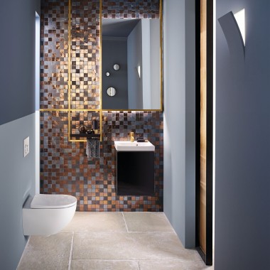 Pogled v sodobno kopalnico za goste z WC školjko Acanto in umivalnikom Acanto pred hrbtno ploščo iz mozaika