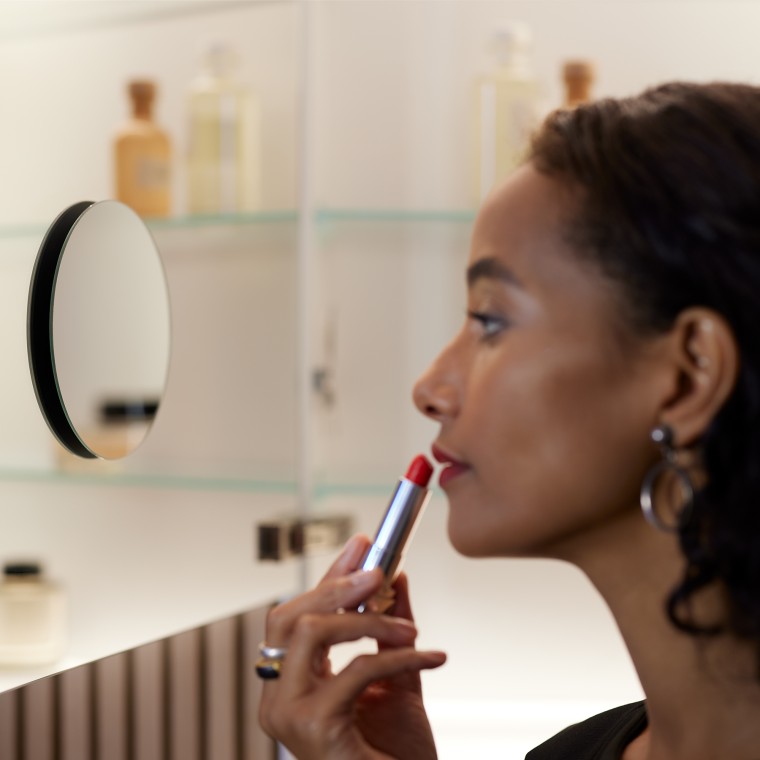 Ženska se liči v ogledalu