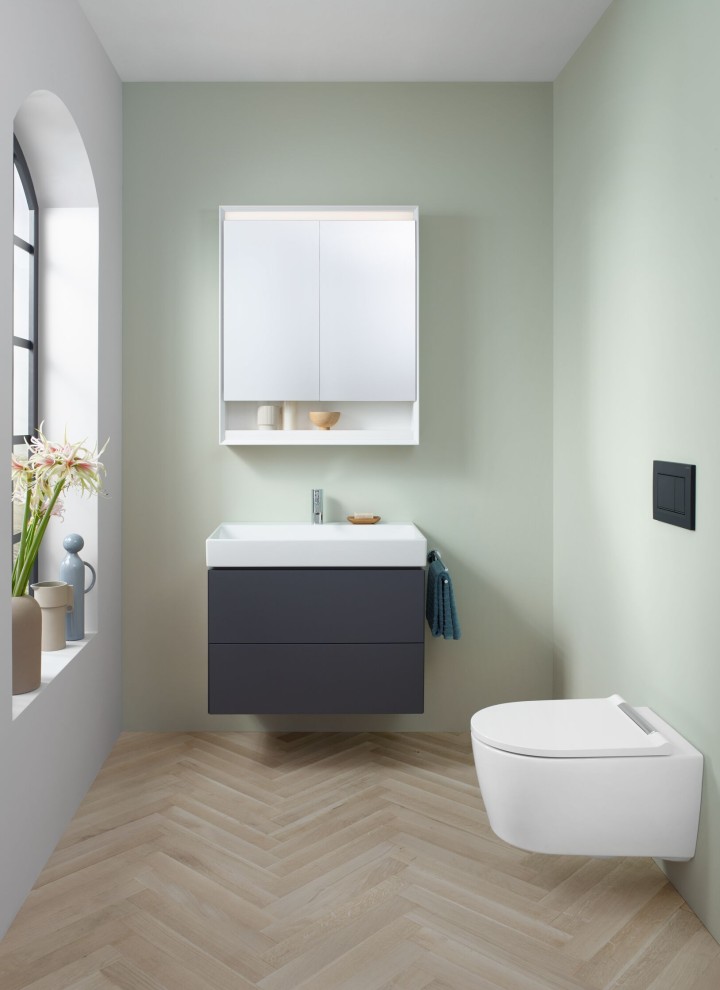 Pogled na WC za goste z visečim WC-jem, omarico z ogledalom in omarico za umivalnik iz kopalniške serije Geberit ONE