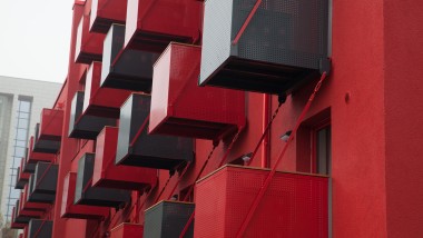 Presenetljiva rdeča fasada s kubičnimi balkoni spredaj je nova paša za oči na Goldsteinstrasse v Frankfurtu na Majni (DE) ( © Geberit)