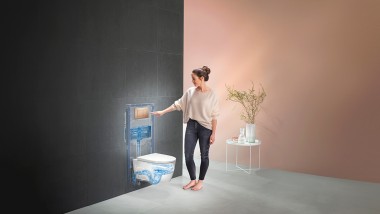Ženska, ki aktivira splakovanje Geberit WC sistema (© Geberit)