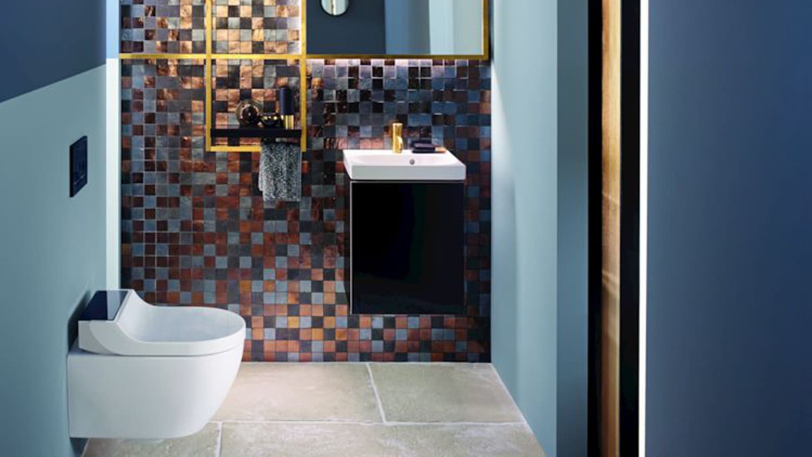 Zlati in bakreni toni dodajo stranišču za goste toplino Zlati in bakreni toni dodajo stranišču za goste toplino