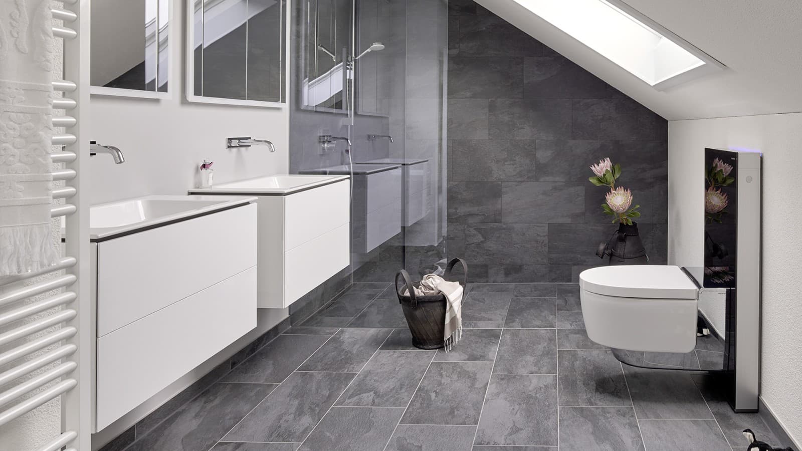 Kopalnica s poševnim stropom in izdelki iz serije kopalnic Geberit ONE ter Geberit AquaClean z elementi Monolith Kopalnica s poševnim stropom in izdelki iz serije kopalnic Geberit ONE ter Geberit AquaClean z elementi Monolith