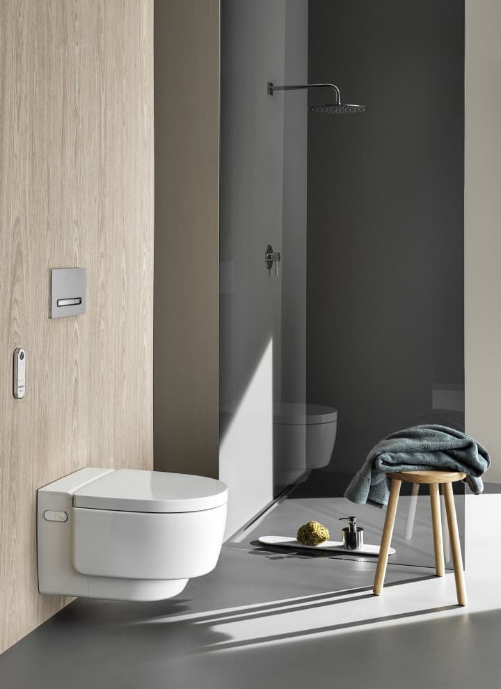 Geberit AquaClean Mera Comfort tuš WC z daljinskim upravljalnikom in aktivirna tipka Sigma50 (© Geberit) Geberit AquaClean Mera Comfort tuš WC z daljinskim upravljalnikom in aktivirna tipka Sigma50 (© Geberit)